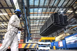 Công nhân chuyển vật liệu tại một nhà máy ở tỉnh Giang Tô, Trung Quốc, ngày 27/8/2021. (Ảnh: AFP/TTXVN) 