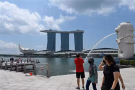 Khách du lịch đeo khẩu trang tại một địa điểm tham quan nổi tiếng của Singapore. (Ảnh: AFP/TTXVN) 