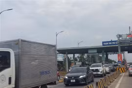 Xe ôtô các loại xếp hàng dài nối đuôi nhau từ trạm thu phí chờ qua cầu Rạch Miễu vào các khung giờ cao điểm. (Ảnh: Chương Đài/TTXVN)