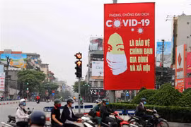 Tranh tuyên truyền về COVID-19 được đặt ở các điểm nút giao thông của Hà Nội. (Ảnh: Thanh Tùng/TTXVN) 