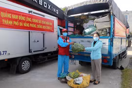 Đại diện huyện Đại Lộc (trái) trao tượng trưng số hàng hóa hỗ trợ người dân vùng bị phong tỏa, cách ly quận Sơn Trà. (Ảnh: Trần Lê Lâm/TTXVN) 