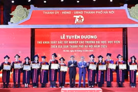 Ông Nguyễn Đắc Vinh, Ủy viên Trung ương Đảng, Chủ nhiệm Ủy ban Văn hóa, Giáo dục của Quốc hội và ông Nguyễn Văn Phong, Phó Bí thư Thành ủy Hà Nội trao Bằng khen của Chủ tịch Ủy ban Nhân dân Thành phố cho các thủ khoa xuất sắc tiêu biểu. (Ảnh: Minh Đức/TTXVN)