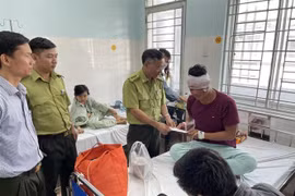 Lãnh đạo Chi cục Kiểm lâm Đồng Nai thăm hỏi, động viên kiểm lâm viên Chìu Văn Hai (kiểm lâm của Vườn quốc gia Cát Tiên) đang điều trị tại bệnh viện. (Ảnh: TTXVN phát)