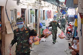 Cán bộ, chiến sỹ Trung đoàn 31, Sư đoàn 309 (Quân đoàn 4) chuyển quà cho nhân dân vùng dịch ở phường 16, Quận 8, TP Hồ Chí Minh. (Ảnh: Thanh Vũ/TTXVN) 