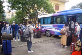 Các công dân lên xe về nhà sau khi hoàn thành thời gian cách ly tập trung. (Ảnh: Đinh Tuấn/TTXVN) 