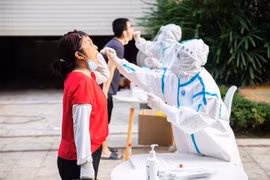 Nhân viên y tế lấy mẫu xét nghiệm COVID-19 cho người dân tại Trung Quốc. (Ảnh: THX/TTXVN) 
