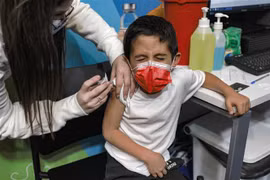 Nhân viên y tế Israel tiêm vaccine phòng COVID-19 của Pfizer/BioNTech cho trẻ em tại Jerusalem ngày 23/11/2021. (Ảnh: AFP/TTXVN) 