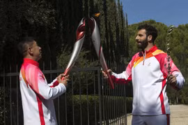 Vận động viên trượt tuyết người Hy Lạp Ioannis Antoniou (phải) truyền ngọn đuốc Olympic của Thế vận hội mùa Đông Bắc Kinh 2022 cho cựu vận động viên trượt băng tốc độ quãng đường ngắn người Trung Quốc Li Jiajun, ở Olympia (Hy Lạp), ngày 18/10/2021. (Ảnh: 