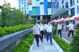 Phó Thủ tướng Chính phủ Vũ Đức Đam, Trưởng Ban chỉ đạo Quốc gia phòng, chống COVID-19 kiểm tra tại điểm tiêm vắc xin 04 dây chuyền tại trụ sở Tập đoàn FPT. (Ảnh: Minh Đức/TTXVN) 