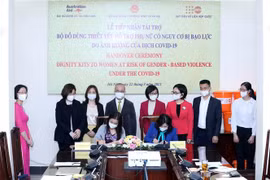 Bà Naomi Kitahara, Trưởng đại diện Quỹ Dân số Liên hợp quốc tại Việt Nam (bên trái) và Thứ trưởng Bộ Lao động- Thương binh và Xã hội Nguyễn Thị Hà (bên phải) ký bàn giao bộ đồ dùng thiết yếu hỗ trợ phụ nữ có nguy cơ bạo lực do ảnh hưởng của dịch COVID-19.