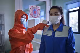 Nhân viên y tế kiểm tra thân nhiệt trước khi vào một nhà máy ở Bình Nhưỡng, Triều Tiên, ngày 16/6/2022. (Ảnh: AFP/TTXVN) 