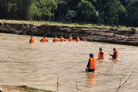 Chính quyền địa phương huy động dân quân, tự vệ, công an và nhân dân tìm kiếm thi thể học sinh. (Ảnh: TTXVN phát)