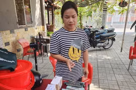 Đối tượng Võ Thị Ngọc Phượng bị bắt quả tang cùng tang vật khi nhận tiền chạy án. (Ảnh: TTXVN phát)