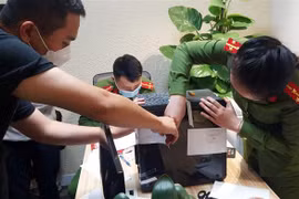 Lực lượng chức năng khám xét và niêm phong, thu giữ tài liệu tại trụ sở FLC. (Ảnh: Phạm Kiên/TTXVN) 