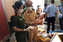 Lực lượng cảnh sát giao thông và Cảnh sát môi trường tiến hành kiểm đếm khoảng 10 tấn thực phẩm đông lạnh không nguồn gốc xuất xứ, bốc mùi hôi thối trên xe tải. (Nguồn: atgt.vn) 