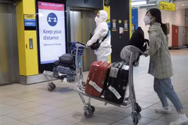 Hành khách đeo khẩu trang phòng lây nhiễm COVID-19 tại sân bay Heathrow ở London, Anh, ngày 1/5/2020. (Nguồn: THX/TTXVN) 