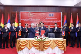 Chủ tịch Ủy ban Trung ương Mặt trận Tổ quốc Việt Nam Đỗ Văn Chiến và Chủ tịch Ủy ban Trung ương Mặt trận Lào xây dựng đất nước Sinlavong Khoutphaythone trao Biên bản hợp tác giữa hai Cơ quan giai đoạn 2022-2026. (Ảnh: Phạm Văn Kiên/TTXVN) 