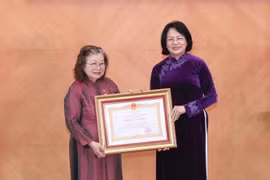 Thừa ủy quyền của Chủ tịch nước, Phó Chủ tịch nước Đặng Thị Ngọc Thịnh trao danh hiệu Anh hùng Lao động thời kỳ đổi mới của Thầy thuốc Nhân dân,Giáo sư, Tiến sỹ Huỳnh Thị Phương Liên. (Ảnh: Minh Quyết/TTXVN) 
