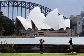 Người dân tập thể dục tại khu vực Cầu Cảng ở thành phố Sydney, Australia. (Ảnh: AFP/TTXVN) 