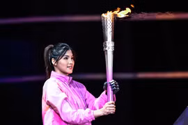 Vận động viên bơi Xu Jialing đã thắp sáng vạc lửa bằng cánh tay sinh học thông minh. (Nguồn: Xinhua)