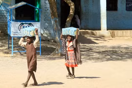 Trẻ em nhận hàng cứu trợ tại trại tị nạn ở Gadaref, Sudan. (Ảnh: AFP/TTXVN)