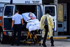 Nhân viên y tế chuyển bệnh nhân nhiễm COVID-19 tới bệnh viện ở Coral Gables gần Miami, Mỹ. (Ảnh: AFP/TTXVN) 