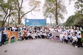 Các nhà ngoại giao quốc tế và gia đình tham gia chương trình đi bộ bên Hồ Hoàn Kiếm kêu gọi bảo tồn thú họ Mèo. (Ảnh: TTXVN phát)