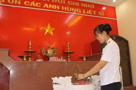 Thượng úy Trần Thị Thủy thắp hương tại phòng truyền thống tưởng niệm 64 liệt sỹ tại Lữ đoàn 146, Bộ Tư lệnh Vùng 4 Hải quân. (Nguồn: TTXVN) 