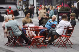Người dân thư giãn tại một quán ăn ngoài trời ở quảng trường Thời đại, New York (Mỹ) khi các quy định phòng dịch COVID-19 được nới lỏng, ngày 7/3/2022. (Ảnh: THX/TTXVN) 