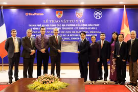 Thông qua Đại sứ Pháp tại Việt Nam Nicolas Warnery, Chủ tịch Ủy ban Nhân dân Thành phố Hà Nội Nguyễn Đức Chung trao tượng trưng 150.000 khẩu trang cho Vùng Ile-de-France. (Ảnh: Lâm Khánh/TTXVN) 