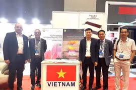 Đại diện Đoàn Hiệp hội Gỗ Bình Dương chụp ảnh lưu niệm với khách tham quan trước gian hàng của Việt Nam tại Hội chợ. (Ảnh: Ngọc Thúy/TXTVN)