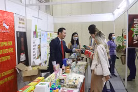 Ông Cao Xuân Thắng, Đại diện Thương vụ Việt Nam tại Singapore, (trái) giới thiệu các sản phẩm chế biến mới của Việt Nam tới các doanh nghiệp quốc tế. (Ảnh: Nguyễn Thúy-Lê Dương/TTXVN)