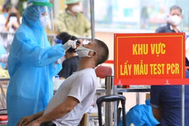 Cùng với việc tiêm vaccine, người dân phường Mễ Trì, Hà Nội được lấy mẫu xét nghiệm sàng lọc SARS-CoV-2, sáng 14/9. (Ảnh: Hoàng Hiếu/TTXVN)