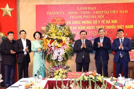 Bí thư Thành ủy Hà Nội Đinh Tiến Dũng chúc mừng ngành Y tế thủ đô. (Ảnh: TTXVN)