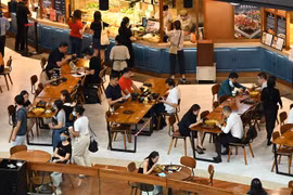 Người dân dùng bữa tại một nhà hàng trong trung tâm thương mại ở Singapore. (Ảnh: AFP/TTXVN) 