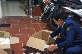 Cán bộ Đội Quản lý Thị trường số 1 kiểm tra thuốc nhãn Tamiflu có dấu hiệu vi phạm. (Ảnh: PV/Vietnam+)