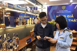 Tổng cục Quản lý thị trường phối hợp với Doanh nghiệp hướng dẫn người tiêu dùng cách nhận biết hàng chính hãng. (Ảnh: Đức Duy/Vietnam+)