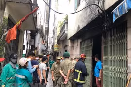 Cơ quan chức năng hỗ trợ các nạn nhân trong vụ cháy chung cư mini tại quận Thanh Xuân. (Ảnh: TTXVN)