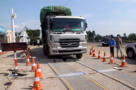 Lực lượng chức năng tiến hành kiểm soát tải trọng xe. (Ảnh: Sỹ Tuyên/TTXVN)