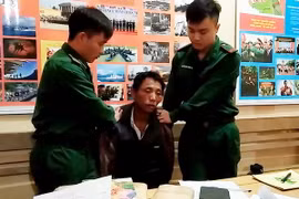 Đối tượng bị bắt cùng tang vật tại cơ quan chức năng. (Ảnh: TTXVN phát)