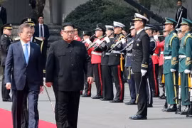 Tổng thống Hàn Quốc Moon Jae-in (trái, phía trước) và Nhà lãnh đạo Triều Tiên Kim Jong-un (phải, phía trước) duyệt đội danh dự tại quảng trường ở làng đình chiến Panmunjom. (Nguồn: YONHAP/TTXVN)