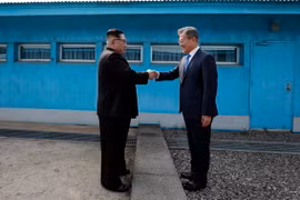 Tổng thống Hàn Quốc Moon Jae-in (phải) đón Nhà lãnh đạo Triều Tiên Kim Jong-un ở đường phân định ranh giới giữa hai miền tại làng đình chiến Panmunjom. (Nguồn: TTXVN)