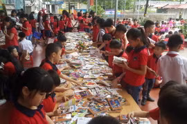 Các em học sinh đọc sách tại Ngày hội. (Ảnh: Hương Thu/TTXVN)