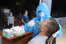 Xuyên đêm triển khai test nhanh phát hiện COVID-19 cho người dân Thành phố Vinh. (Ảnh: Bích Huệ/TTXVN)