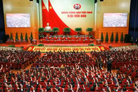 Các đại biểu biểu quyết, thông qua Nghị quyết Đại hội XIII của Đảng. (Ảnh: TTXVN)
