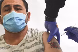 Nhân viên y tế tiêm chủng vaccine ngừa COVID-19 cho người dân. (Ảnh: AFP/TTXVN)