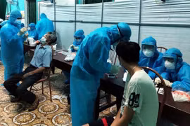 Nhân viên y tế lấy mẫu bệnh phẩm của người dân. (Ảnh: TTXVN phát)