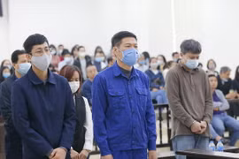 Bị cáo Nguyễn Nhật Cảm và các đồng phạm nghe Tòa tuyên án tại phiên tòa xét xử sơ thẩm vụ án Vi phạm quy định về đấu thầu gây hậu quả nghiêm trọng xảy ra tại CDC Hà Nội ngày 12/12/2020. (Ảnh: Doãn Tấn/TTXVN)