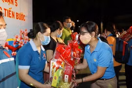 Lãnh đạo Liên đoàn Lao động thành phố trao tặng quà và tiền Tết cho người lao động có hoàn cảnh khó khăn ở quận 5 trong Chương trình "Tết Sum vầy." (Ảnh: Thanh Vũ/TTXVN)