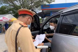 Lực lượng cảnh sát giao thông kiểm tra giấy tờ lưu thông của các lái xe. (Ảnh: Nguyễn Văn Cảnh/TTXVN)